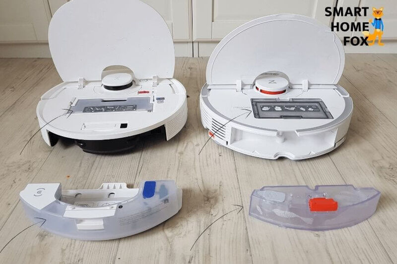 Staubbehälter und Wasserbehälter eines Saug-Wisch-Roboters stehen nebeneinander auf dem Boden